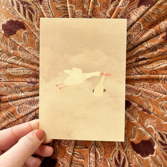 Ansichtkaart met een ooievaar en babydoekje, ontworpen door Lievigheidje en geleverd inclusief kraft envelop.