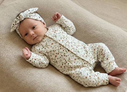 Detail van handgemaakt newborn boxpakje in Millefleur, zachte babykleding uit eigen atelier