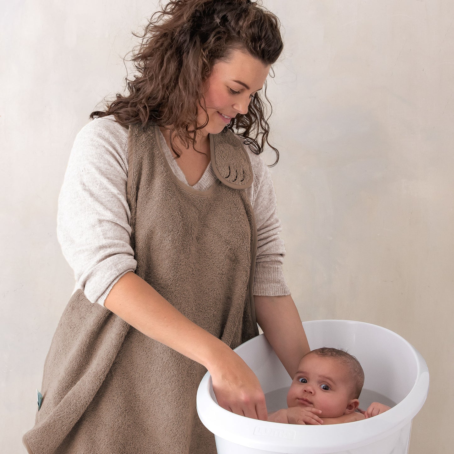 Ouder draagt handsfree badcape Mocha om de nek