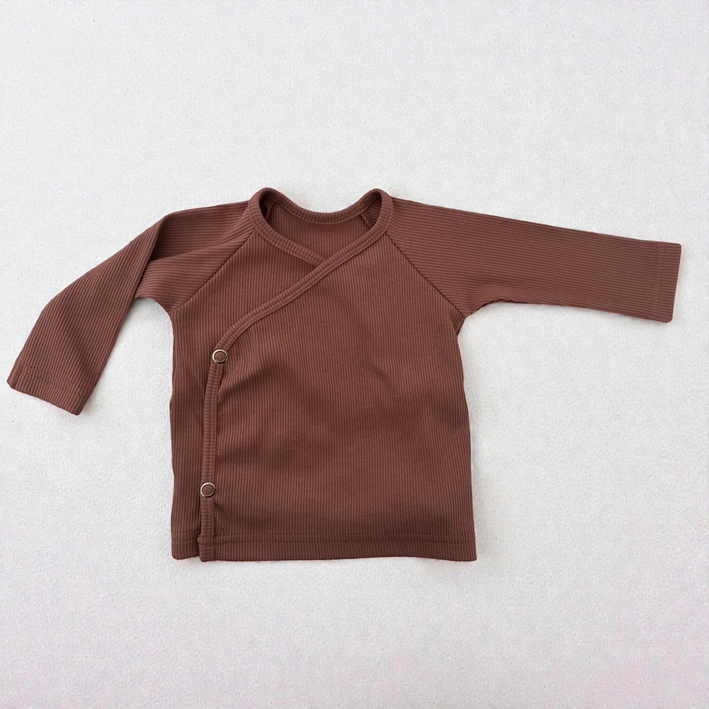 Detail van baby overslagshirt Kleiroze – rib tricot met drukknopen