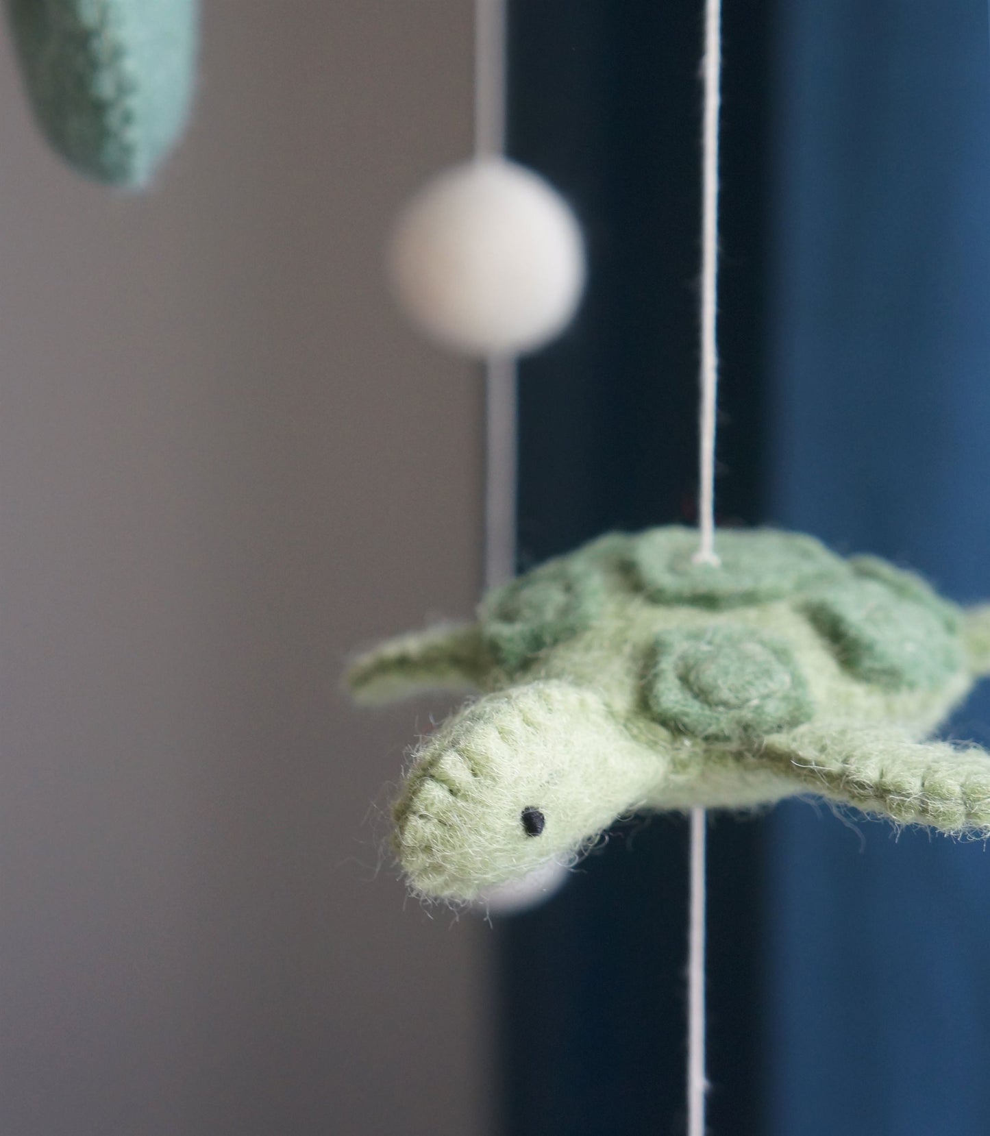 wiegmobiel van 100% wolvilt, fair trade geproduceerd in Nepal – perfect als rustgevende en natuurlijke decoratie voor de babykamer.