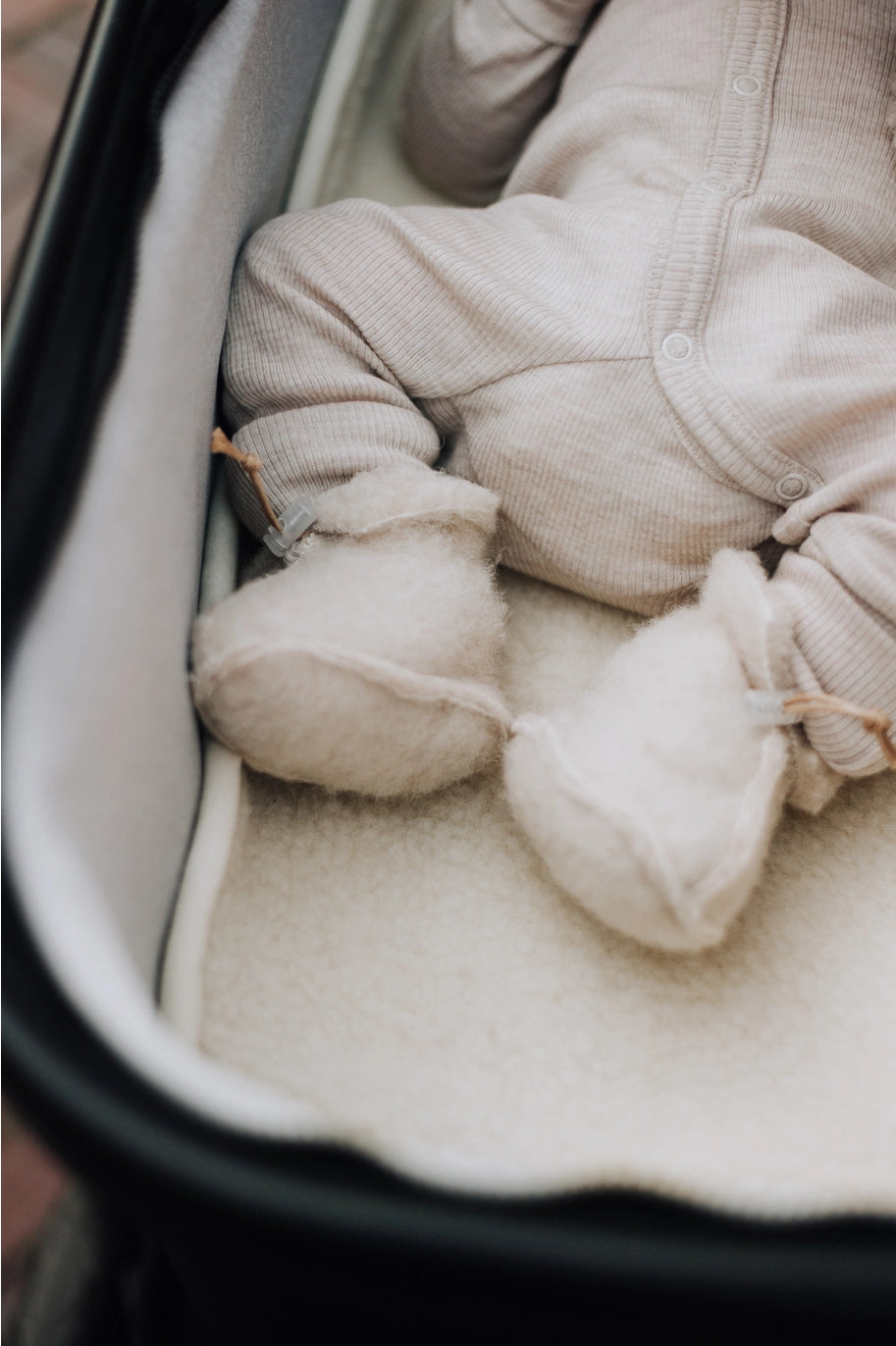 Detail van de zachte structuur van merino wollen babyslofjes voor baby’s