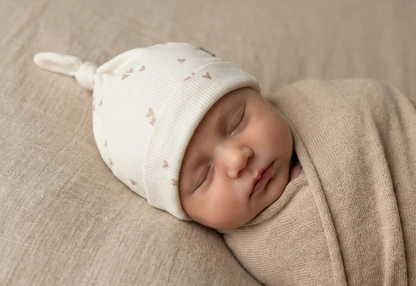 Baby draagt mutsje hartjes licht beige Barefoot Baby