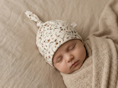 Baby draagt mutsje millefleur Barefoot Baby