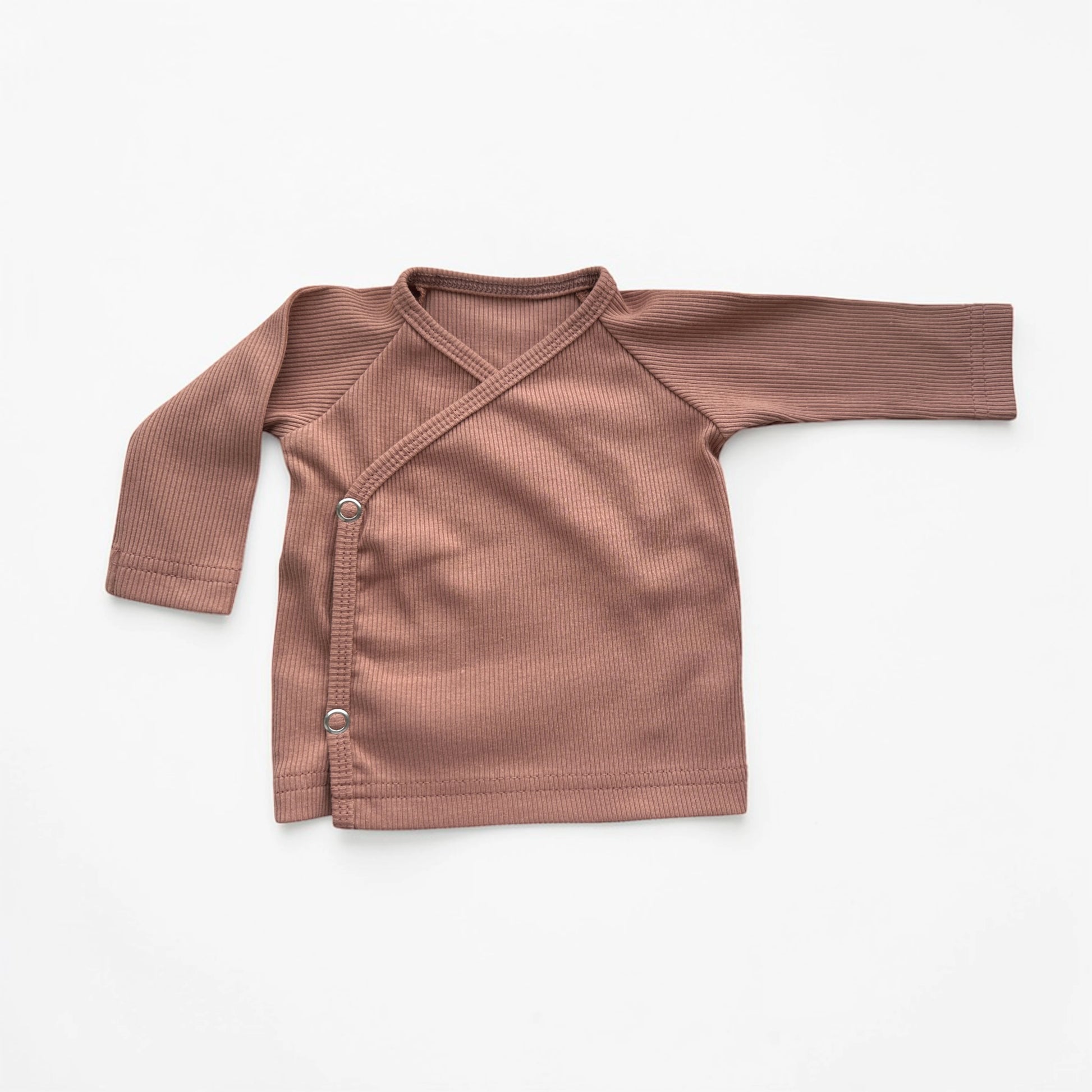 Detail van rib overslagshirt baby Perzik – zachte stof met drukknopen